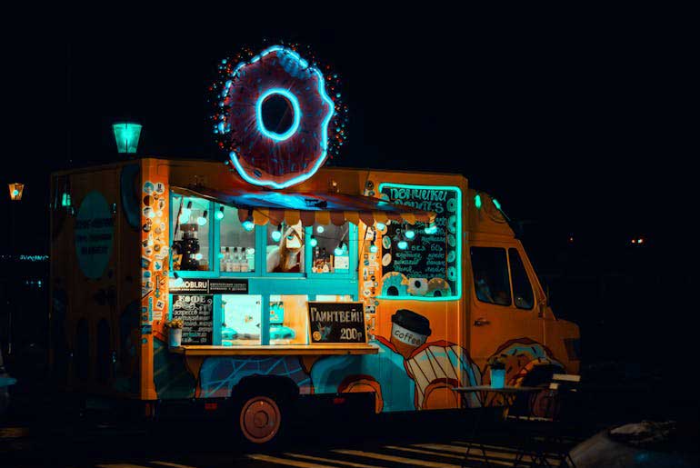 Food truck at night lit by neon lights