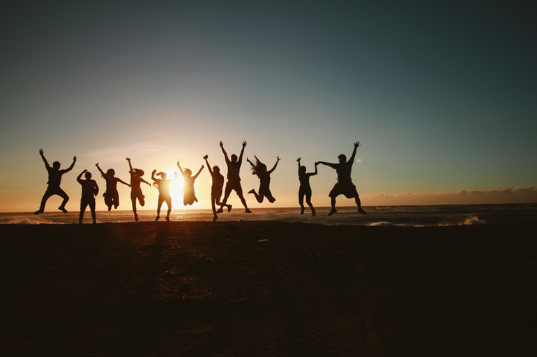 People jumping for joy at sunset