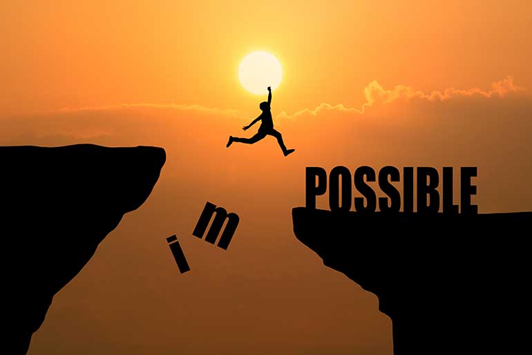 Person jumping across chasm to the word possible