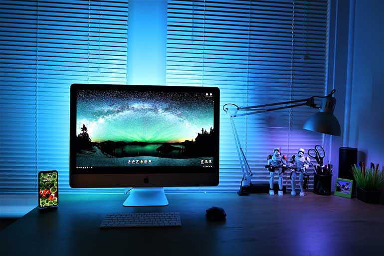 iMac and iPhone on white desk with a blue background