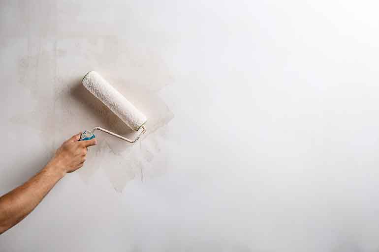 White painting roller against a wall