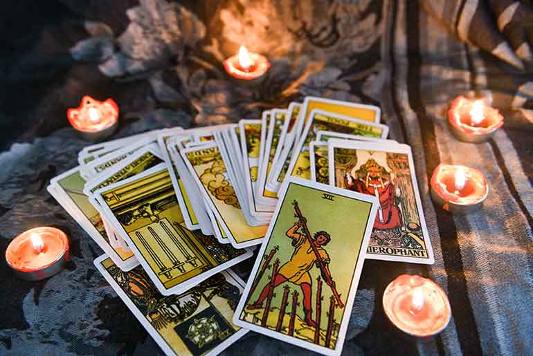 Deck of tarot cards surrounded by candles