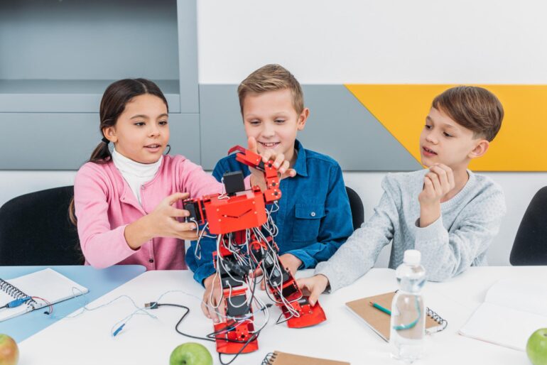 https://cdn.flippingheck.com/wp-content/uploads/2021/04/three-children-building-a-small-robot-for-stem-cla-e1619667900945.jpeg