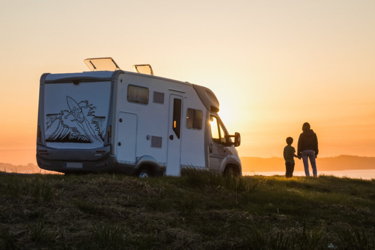 Family watching the sunset by their motor home