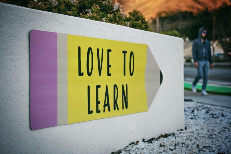 "Love to learn" pencil shaped sign by the side of a path
