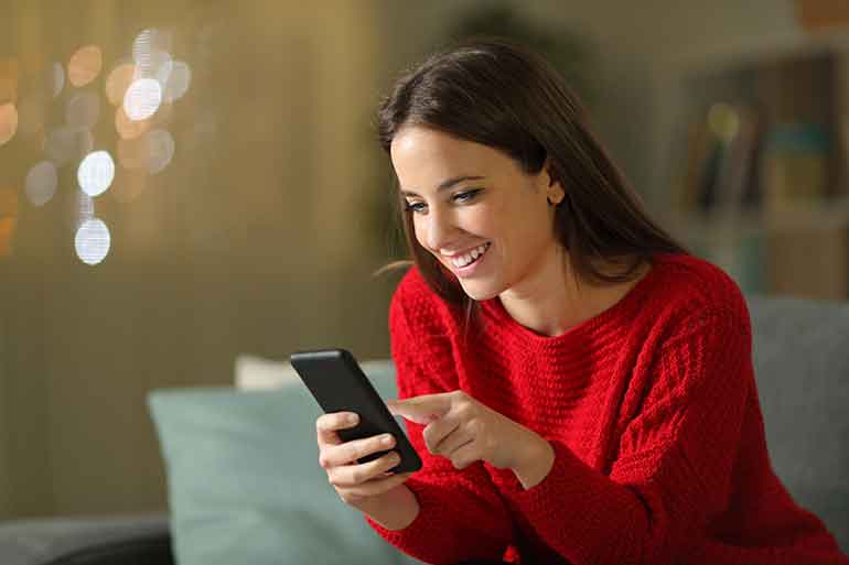 Smiling woman looking at her smartphone
