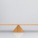 A piece of wood balancing on a wooden triangle