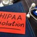 The text "HIPPA violation" written on red paper