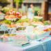 Various cupcakes and sandwiches on cake stands at an