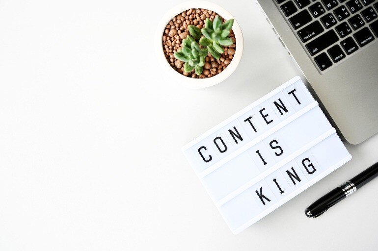 The text "Content Is King" next to a laptop