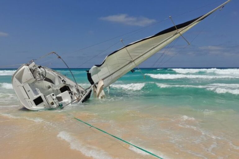 A sailing boat run aground on a beach