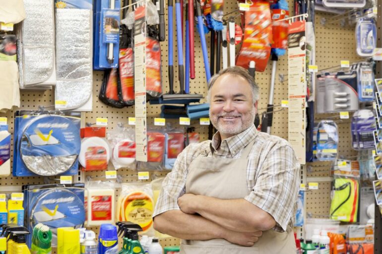 Smiling shop keeper in front of a product display