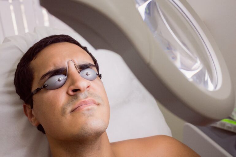 Person wearing protective eyewear lying on a salon bed