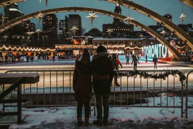 Two people standing by an outdoor skating rink in Toronto