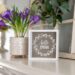 Spring flowers in a vase with a small framed print that says "Hello Spring"