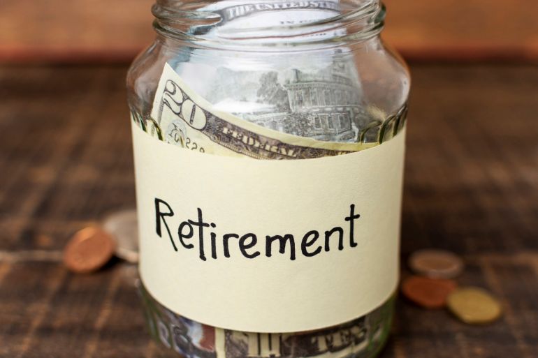 Clear jar with the word "retirement" on it containing dollar bills