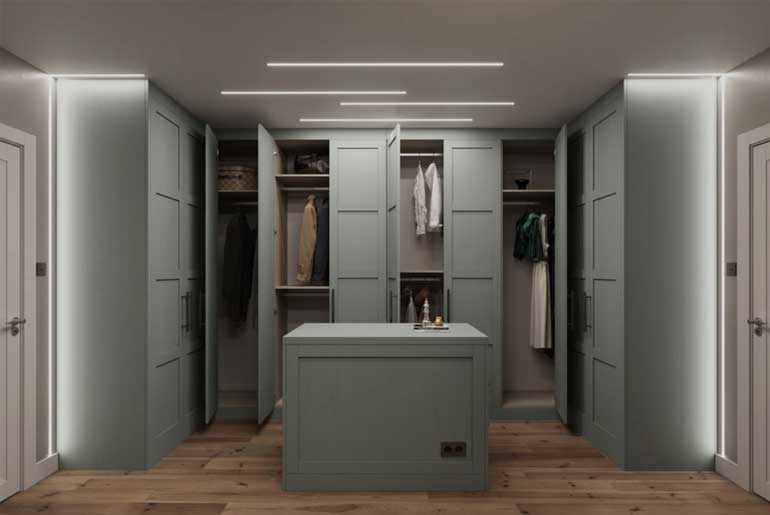 Pastel green wardrobes in a large walk-in closet