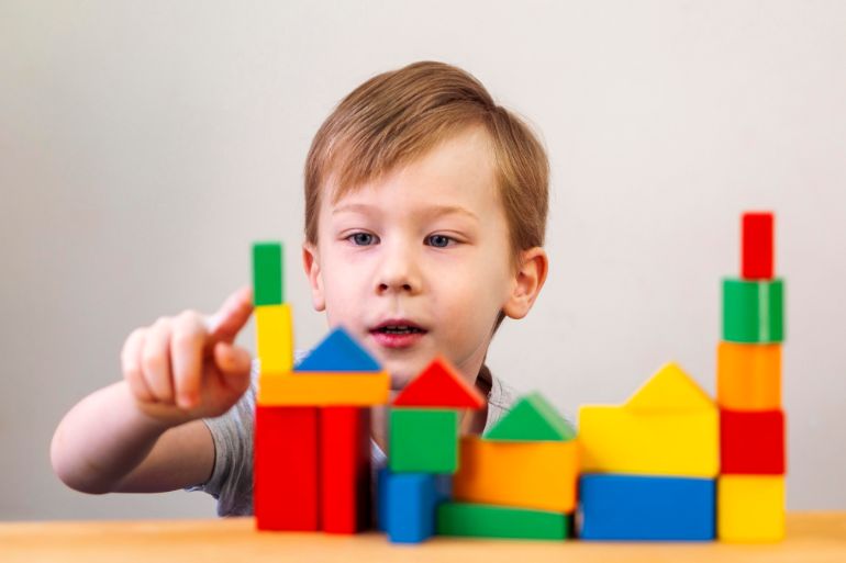 Small child playing with brightly coloured toy blocks