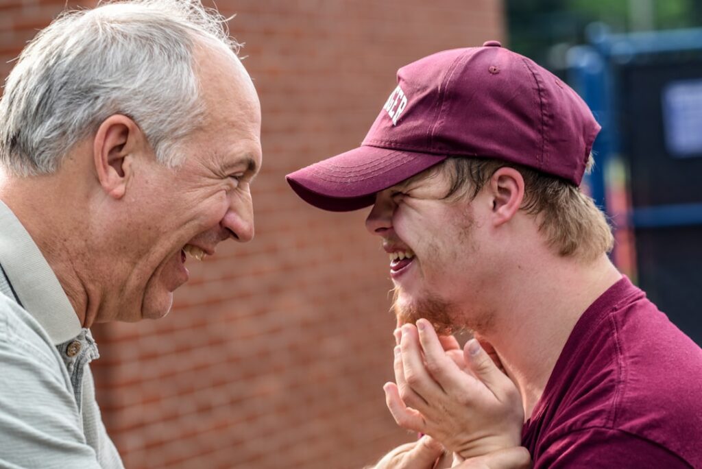 An older man smiling at a younger man